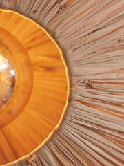 Innenansicht der Good&Mojo Deckenleuchte Panama Raffia Octogon S mit warm leuchtender Lampe und radial verlaufenden Raffiafasern.