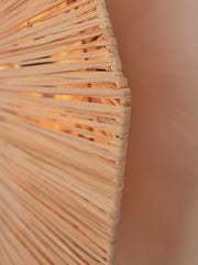 Detailaufnahme des Raffia-Geflechts der Deckenleuchte Good&Mojo Panama, durch das warmes Licht zwischen den Fasern leuchtet.