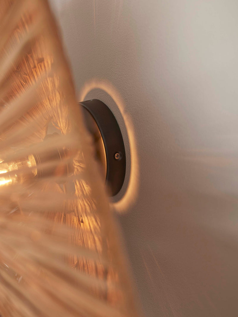 Detailaufnahme der Deckenleuchte Panama von Good&Mojo: geflochtener Raffia-Schirm, warmes Licht, dunkle Metallbefestigung.