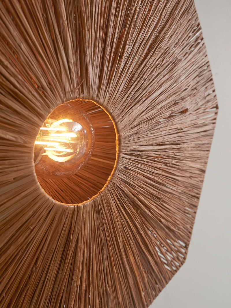 Detailansicht der Wandleuchte Good&Mojo Panama: radial geflochtener Raffiaschirm in Braun, im Zentrum leuchtet eine Glühlampe.