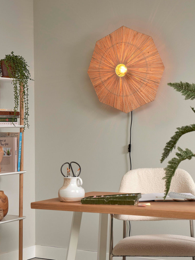 Good&Mojo Wandleuchte Panama aus Raffia: achteckiger, braun geflochtener Schirm, eingeschaltet in einem Wohnraum.