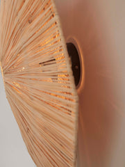 Detailansicht der Wandleuchte Good&Mojo Panama aus Raffia mit strahlenförmig geflochtenem Schirm und dunklem Wandteller.