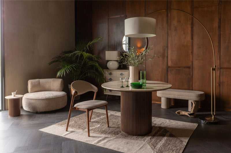 Esszimmer mit rundem Tisch, Stühlen, Sessel, Beistelltisch, Bank, Stehlampe und Pflanzen